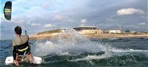 kitesurfeur de dos devant la base nautique d'urville